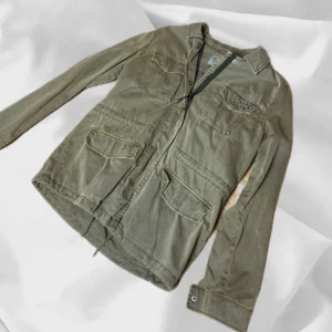 Field Jacket Grön - Grön field jacket i storlek Small! – enkel att matcha och skön att bära. Ett stilrent val, noggrant utvalt med omsorg av AM Clothing.  📩 Frågor? Hör gärna av dig! 📲 Följ oss här på Plick för fler uppdateringar. ♻️ Tack för att du handlar mer hållbart med AM Clothing!