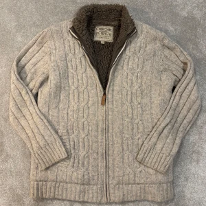 Stickad kofta med fodring/päls - Säljer denna riktigt snygga beiga  mönsterstickade kofta med fodring/päls i hela koftan! Koftan är i prima skick, inga defekter! Size L passar även M. Skriv vid funderingar!