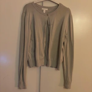 kofta från H&M - Säljer nu den här söta koftan från H&M, jag skulle säga att färgen är lite oklar nästan som en blandning av beige, grå och ljus grön beroende på ljus. Bara att skriva för fler bilder🥰