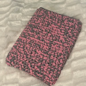 Grå och rosa virkat datorfodral - Handgjort virkat datorfodral i rosa och grått. Aldrig använt, gjort för dator i måtten 20 x 29.5 cm men passar även för en dator som är lite större. Får även plats med anteckningsböcker/pennor etc. Skriv om du har funderingar över storlek eller vill beställa ett eget i valfri färg/färger!