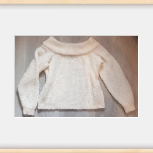 Så fin Offshoulder stickad tröja i vitt - Supermjuk och fluffig offshoulder stickad tröja i vit färg. Tröjan har bred krage som vilar över axlarna och långa ärmar. Perfekt för dig som gillar en stilren och mysig look. Passar till både jeans och kjol.
