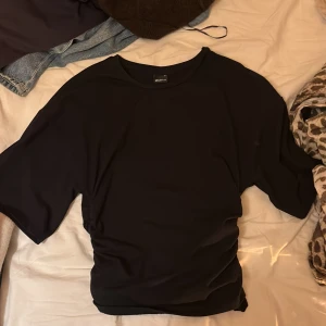 Svart t-shirt från Gina Tricot - En stilren svart t-shirt från Gina Tricot i storlek S. T-shirten har klassisk rund hals och korta ärmar, med en loose passform som ger en avslappnad vibe. Perfekt att matcha med jeans eller kjol för en enkel och snygg look.