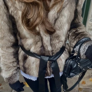 Brun pälsjacka med skinn bälte  - Säljer en fluffig och snygg brun pälsjacka från Cubus. Jackan är hel fodrad, har dold knäppning och ett svart bälte i skinn i midjan. 