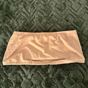 Beige bandeau tubtopp från SHEIN - Säljer en enkel och snygg beige bandeau tubtopp från SHEIN i storlek EU 40/42. Toppen är axelbandslös och har en mjuk, stretchig passform som sitter skönt mot kroppen. Perfekt att styla med jeans eller kjol för en chill look.