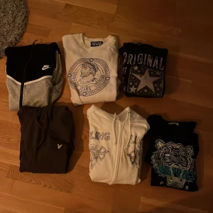 Rensar garderoben nu så säljer till riktigt bra pris - Nike hoodie i svart och grått med vit detalj och dragkedja framtill. Klassisk logga på bröstet och huva med snörning. Perfekt för dig som gillar sportig stil och vill ha något bekvämt och snyggt.