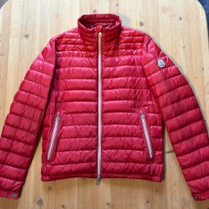 Moncler Daniel Jacket - Moncler Daniel Jacket, selling this incredibly nice Moncler jacket model: Daniel, in a beautiful red color❤️. The jacket is intended for men. The jacket is size 2 which corresponds to a Small - Medium. Incredibly nice and popular model, secure yourself a super nice jacket now that autumn is here🙌🏻🤩. The condition of the jacket is as pictured, nicely used, just a little general wear, but no huge signs of wear. The jacket has a new price of 13 500NOK. 700++ sales references so here you are shopping 