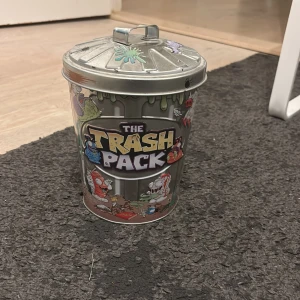 The Trash Pack Metallburk - Samlingsburk från The Trash Pack, tillverkad av metall med färgglada detaljer. Den är i nästan nytt skick. Perfekt för förvaring av Trash Pack-figurer eller småsaker. Lock med handtag ingår. Denna vara är i special limited edition och går inte att köpas längre. Den köptes för 3599kr ny. Säljer för 700kr. Pris kan diskuteras.