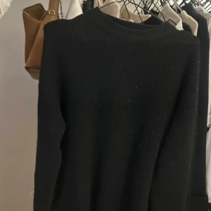 Svart stickad långärmad klänning  - En svart stickad klänning med lång ärm och rund hals. Enkel och clean design som funkar till allt, perfekt för dig som gillar basic vibes. Mjuk och skön känsla, passar dig som vill ha en klassisk look.