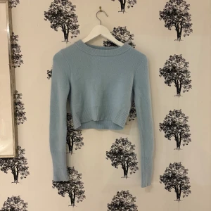 Ljusblå croppad stickad tröja Zara - Superfin ljusblå croppad stickad tröja från Zara med rund hals och långa ärmar. Tröjan har bred ribbad kant vid hals och nederdel, vilket ger en snygg och modern look. Perfekt att styla med höga jeans eller kjol.