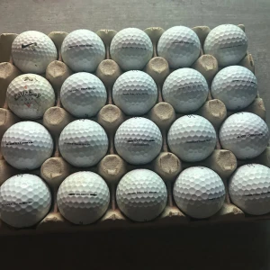 Begagnade Titleist, Callaway & Nike golfbollar (20-pack) - 20-pack blandade golfbollar från Titleist, Callaway och Nike. Flera modeller som Pro V1, NXT Tour, Velocity och Callaway. Bollarna är begagnade, vissa har mindre slitage eller märken, men de flesta är i gott skick och redo för spel.