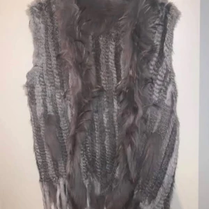 Grå pälsväst med stickade detaljer - Pälsväst. Oanvänd