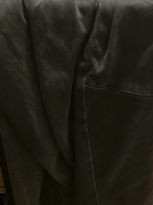 Svart skinnjacka i klassisk modell - Säljer en svart skinnjacka med stilren design och markerade sömmar. Jackan har en slät yta och är tillverkad i skinn, vilket ger en cool och tidlös look. Perfekt för dig som vill ha en enkel men snygg jacka till garderoben.