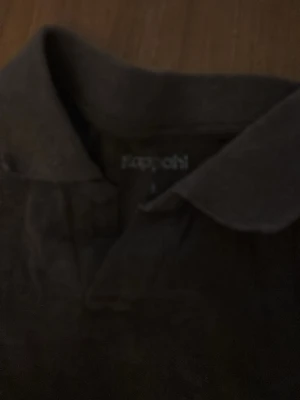 Brun kortärmad pike’ från Kappahl - Säljer en enkel brun pike’ från Kappahl. Skjortan har korta ärmar, klassisk krage och är gjord i mjuk bomull. Perfekt till jeans eller shorts för en avslappnad look.