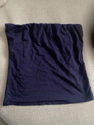 Mörkblå tubtopp XS från Shein  - En enkel och stilren mörkblå tubtopp i storlek XS. Toppen är axelbandslös och har en mjuk, stretchig känsla som gör den bekväm att bära. Perfekt att matcha med jeans eller kjol för en clean look.