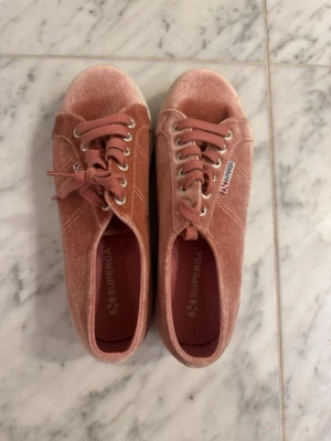 Rosa Superga sneakers i sammet - Säljer ett par snygga Superga sneakers i rosa med sammetsyta. Aldrig använda och är då i mycket bra skick. Köptes för runt 900kr