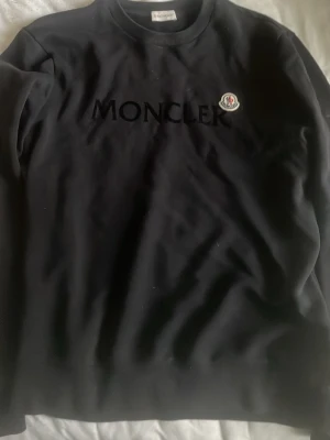 Navy sweatshirt från Moncler - Säljer en navy sweatshirt från Moncler med broderad logga på bröstet och stort Moncler-tryck framtill. Klassisk rund halsringning och långa ärmar. Köpt på nk i Göteborg för dryga ett år sen. Har tyvärr tappat kvitto men som tur är är de bara att scanna nfc koden så kommer ni till monclers hemsida som sedan skickar ett mail till er att varan är äkta bra för framtida äkthetsbevis. Original pris är 5899kr