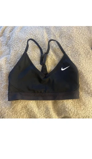 Svart sport-bh från Nike  - Säljer en svart Sport-bh från Nike. Säljer den då jag råka beställa i fel storlek o den är för liten för mig. 