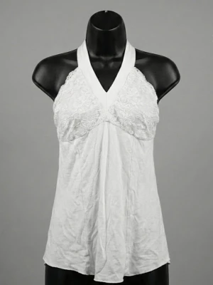 Vit halterneck linnetopp med spets - Säljer en vit halterneck linnetopp med spetsdetaljer över bysten och ryggen. Toppen har knyt i nacken och är ärmlös med en lätt utsvängd passform. Perfekt för sommarens varma dagar och ger en romantisk vibe med sina blommiga spetsinslag.