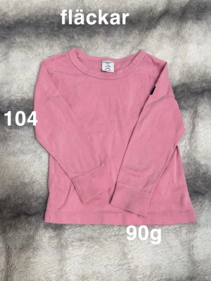 Rosa långärmad topp - En enkel  rosa långärmad topp. Klassisk rund halsringning och raka ärmar. Perfekt till vardags och lätt att matcha med andra plagg.🌸 .Fläckar. Storlek 104