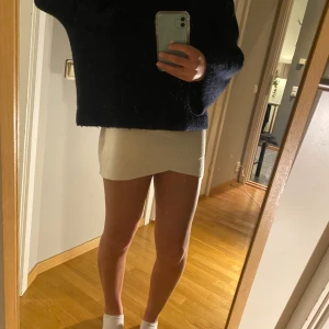 Vit kortkjol - Snygg vit kortkjol i en stilren design. Perfekt för att matcha med en oversized tröja eller en tight topp. Kjolen har en enkel och elegant look.