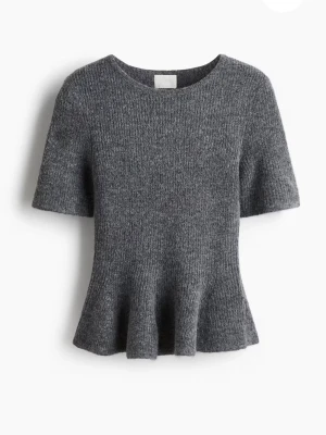 RIBBSTICKAD PEPLUMTOPP - En figurnära topp i mjuk, ribbstickad kvalitet. Toppen har rund halsringning, kort ärm och utställt skört.