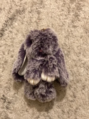  Lila fluffkanin - Nyckelring som du kan hänga på väskan som är formad som en lila kanin. Enkel att hänga på väskan och väldigt fluffig liten gosedjur kanin. Frakten är ca 22-100kr beroende på vikten på produkten . Kontakta mig om du vill köpa.
