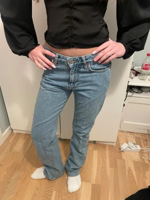 Levi's 501 ljusblå raka jeans - Säljer ett par klassiska Levi's 501 jeans i ljusblå tvätt. Jeansen har rak passform, normal midja och fem fickor. Tillverkade i slitstarkt bomullsjeansmaterial med knappgylf och ikoniska bakfickor. Perfekta till en avslappnad look.