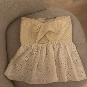 Beige broderad tubtopp med spets - Säljer en söt beige tubtopp med virkad överdel och omlott-detalj framtill. Nästan aldrig använd!