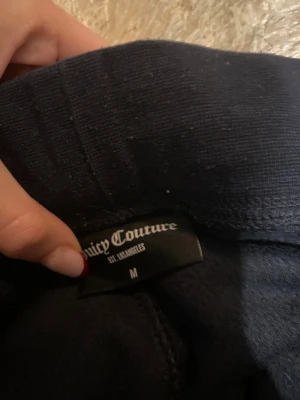 Marinblåa velourbyxor Juicy Couture M - Marinblå mjukisbyxor från Juicy Couture i storlek M. Saknar detaljerna på snörningen. 