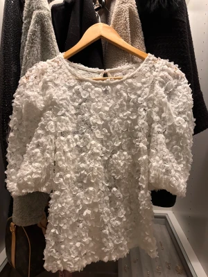 Vit blommig blus från Holly & Whyte - Superfin vit blus från Holly & Whyte helt ooanvänd, blusen har 3d blommor över hela ytan säljer då den inte kommer till användning