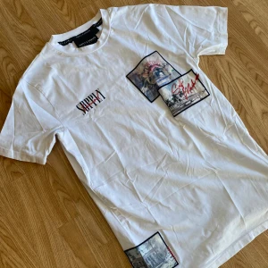 Vit t-shirt Supply & Demand  - Vit t-shirt från Supply & Demand med tryckta fotomotiv och textdetaljer på framsidan. Använd ett fåtal gånger