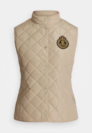 Beige quiltad dunväst med emblem - Snygg beige dunväst från Ralph Lauren med quiltat mönster och ett broderat emblem i svart och guld på bröstet. Västen har hög krage, tryckknappar och två fickor. Perfekt för lager-på-lager och en clean look.