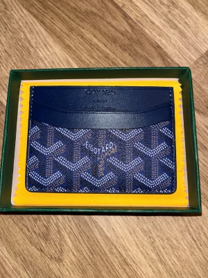 Blå  plånbok med mönster - Snygg blå plånbok mrf grafiska mönster i vitt och brunt. 