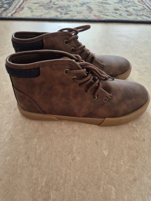 Kängor - Bruna kängor i skinnimitation (mockastil) med snörning och bekväm gummisula. Använda mycket lite, i fint skick.