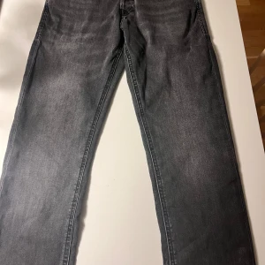 Slim Glenn svarta jeans storlek 29/32 - Snygga svarta jeans från Slim Glenn i slim fit-modell. Jeansen har klassisk femficksdesign, raka ben och diskret tvättad look. Passar dig som gillar en smalare siluett och stilrena detaljer. Perfekt för dig som vill ha en modern och enkel jeansstil.