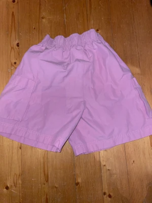 Ljuslila loose  shorts med snörning - Säljer ett par ljusrosa  shorts med loose passform och elastisk midja med snörning. De har praktiska sidofickor ,jätte gulliga men använder inte ofta❤️