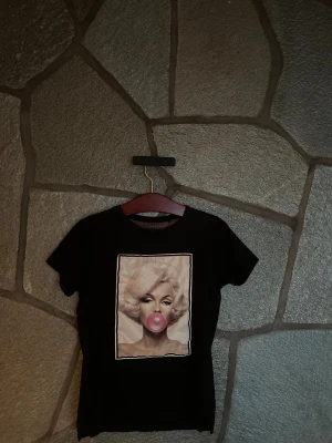 Svart t-shirt Limitato x Michael Moebius - Svart t-shirt från Limitato i samarbete med Michael Moebius. Framsidan har ett stort tryck. T-shirten har klassisk rund hals och korta ärmar, tillverkad i mjuk bomull för skön passform.