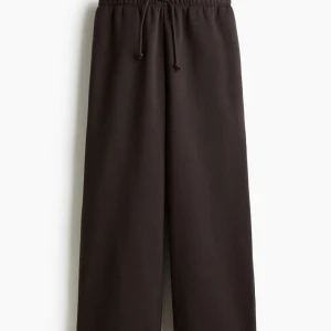 Bruna wide mjukisbyxor med snörning - Säljer ett par bruna mjukisbyxor med breda ben och skön passform. Byxorna har elastisk midja med snörning och sidofickor. Perfekta för chill dagar och har en loose, avslappnad stil. Materialet är mjukt och bekvämt. Storlek S. Helt nya säljer pga glömt returnera beställning.