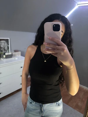 Fyra ribbade linnetoppar från KappAhl - Säljer ett paket med fyra ribbade linnetoppar från KappAhl i storlek 170, men passar XS och S. Färgerna är svart, ljusrosa, grön och ljusgrå. Alla har rundad hals och ärmlös design, perfekta att matcha med jeans eller shorts. Materialet är mjuk bomull med stretch för skön passform.