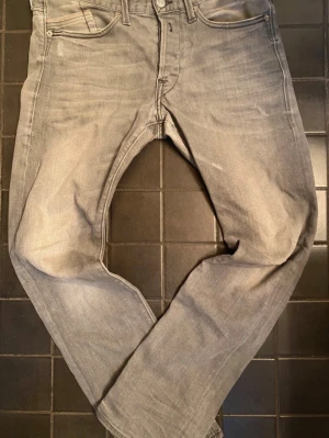 Grå replay anbass jeans - Grå jeans från replay med modellen anbass. Jeansen är i ett mycket bra skick där dom inte är använda så mycket. Storleken är 32/31.