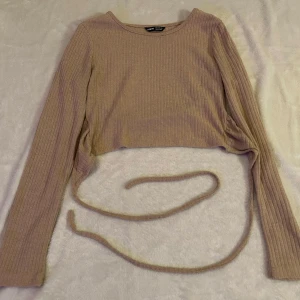 Långärmad topp  - Säljer en långärmad topp i aprikos färg från Shein, storlek S. Toppen har en snygg knytning i ryggen och är i fint skick.