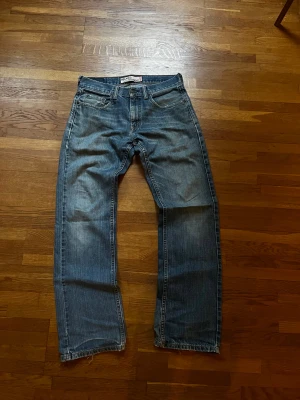 Levi's 559 Relaxed Straight jeans blå - Blå Levi's 559 Relaxed Straight jeans med klassisk femficksdesign och slitna detaljer vid benslut. Jeansen har rak passform och relaxed fit, med medelhög midja och knappgylf. Perfekta för dig som gillar en chill och tidlös look.