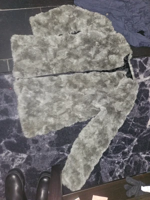 Grå pälsjacka från H&M - Säljer en fluffig grå pälsjacka från H&M i storlek L. Jackan har långärmade ärmar och är tillverkad i syntetiskt pälsmaterial med svart innertyg. Perfekt för dig som vill ha en cool och mysig look under höst och vinter.
