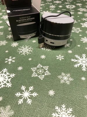 United SPK2502 Bluetooth Speaker - Kompakt Bluetooth-högtalare med färgskiftande ljus. Levereras med originalkartong, laddkabel och manual. Stöd för microSD, USB och AUX. Snygg design, ser ut att vara i mycket gott skick utan synligt slitage.