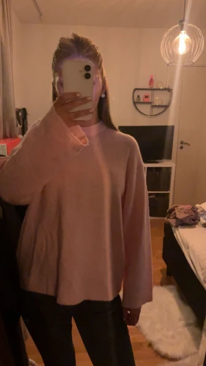 Ljusrosa oversized stickad tröja -  stickad tröja i ljusrosa färg med rund hals och långa ärmar. Tröjan har en loose passform. Knappt använd