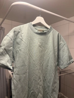 Ljusgrön basic t-shirt i bomull - Säljer en enkel ljusgrön t-shirt med rund hals och korta ärmar. Modellen är loose fit och tillverkad i mjuk bomull, perfekt för en chill och avslappnad stil. Passar dig som gillar minimalistiska plagg och softa färger.