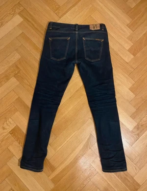Nudie selvage lean dean  - Jeansen är lean dean och har en slim passform- de är gjorda i i högkvalitativ selvage denim som åldras snyggt med tiden- nyrpis är 2000. Moddelen på bilden är 182 och väger 68kg