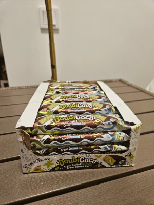 DoubiCoco Cocoa Coated Pistachio Cream Coconut Bar - Pris: 20 kr/st – HELA LÅDAN: 399 kr (23 st) DoubiCoco är en läcker kokosbar med pistagekräm, täckt av kakao. Förpackningen innehåller 23 stycken individuellt inslagna bars. Perfekt för dig som älskar exotiska smaker! Innehållet är i nyskick.                     ✔ Krämig kokosfyllning ✔ Pistagekräm för extra smak ✔ Kakaotäckt – dubbelt så gott ✔ 2 bitar per förpackning ✔ 23 st i lådan