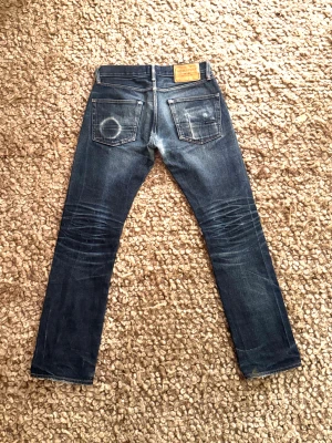 Selvage jeans - Nu säljer vi dessa otroligt feta selvage jeans med sjuka fades! Från märket Indigofera. Storlek W31 L34. Jeansen har blivit lagade i grenen men fortfarande lite slitning där, kolla bild 3. Lite smuts på höger ben längst ner vid foten, kolla bild 1.                                     Mvh Garçon Studios