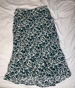 Underbar grön/vit kjol från stockho lm, maxi/midi - Supersöt kjol från stockholm med vina växt tryck / blom tryck. Den är maxi eller midi i längd beroende på hur lågt man har den och hur långa ben man har. #sommar #långkjol #blommig 